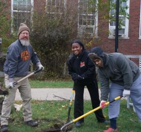 Multiple volunteers planting a tree at Buffalo State